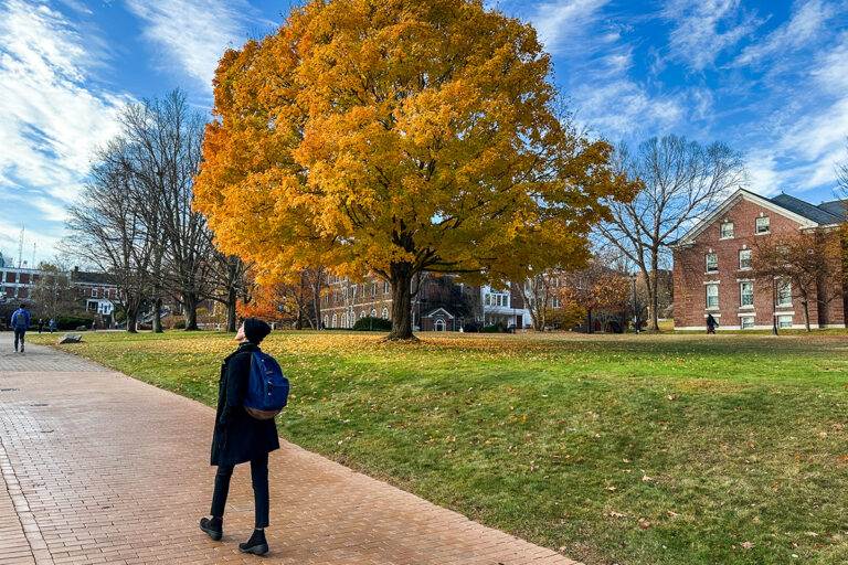 photo of student walking on campus during fall