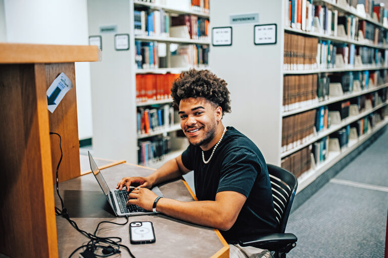 image of student in library at a computer